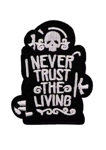 Schwarzer gestickter Aufnäher mit einem Totenkopf und der Aufschrift ’I NEVER TRUST THE LIVING’.