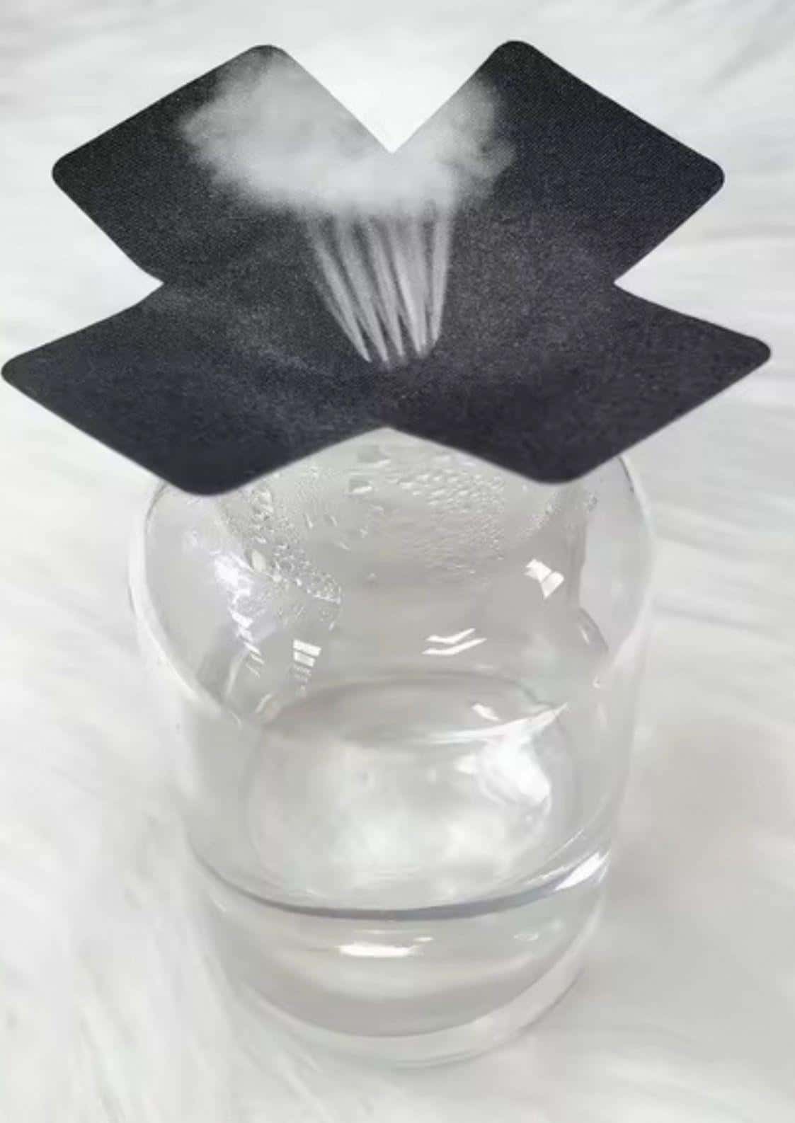 Schwarze nippel pasties eat me in kreuzform mit weißem nebelausstoß auf glas jar für gothic horror dark fashion