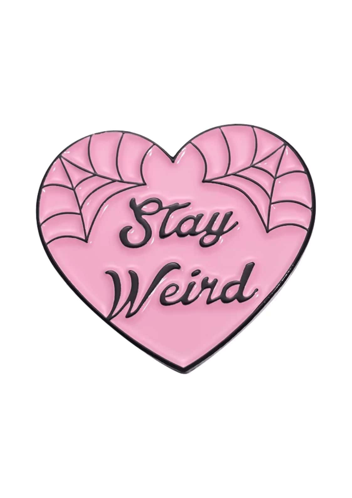 Rosa herzförmiger Email-Anstecker mit schwarzer Spinnennetz-Verzierung und dem Spruch ’stay weird’ in einer kursiven Schrift.