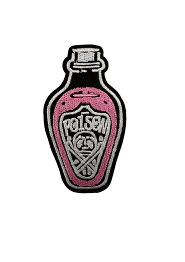 Pink besticktes poison pink patch in flaschenform mit schwarz und silber für eine gothic-inspirierte note auf schwarzem hintergrund