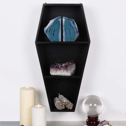 Schwarzes sarg regal wandregal in sargform mit drei fächern für geoden kristalle und salbeibündel im dunklen interieur
