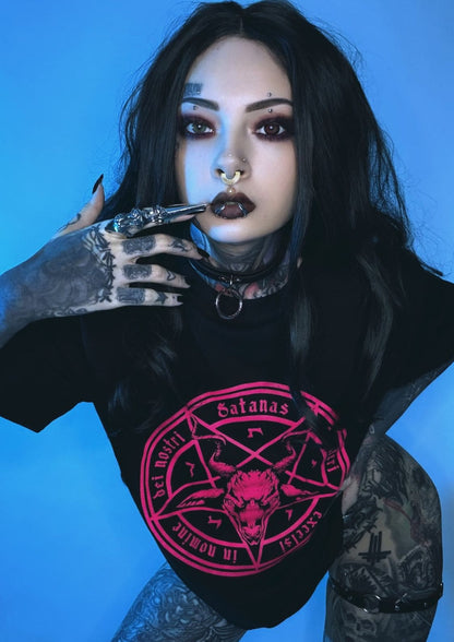 Schwarzes T-Shirt mit einem lebendigen pinken runden Grafikmotiv, das einen dämonischen Kopf und okkulte Symbole zeigt.