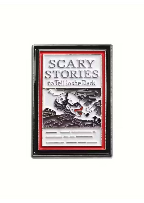 Eine rechteckige Emaille-Anstecknadel, die das Cover von ’Scary Stories to Tell in the Dark’ zeigt, mit einer grotesken Skelettfigur mit roten Akzenten.