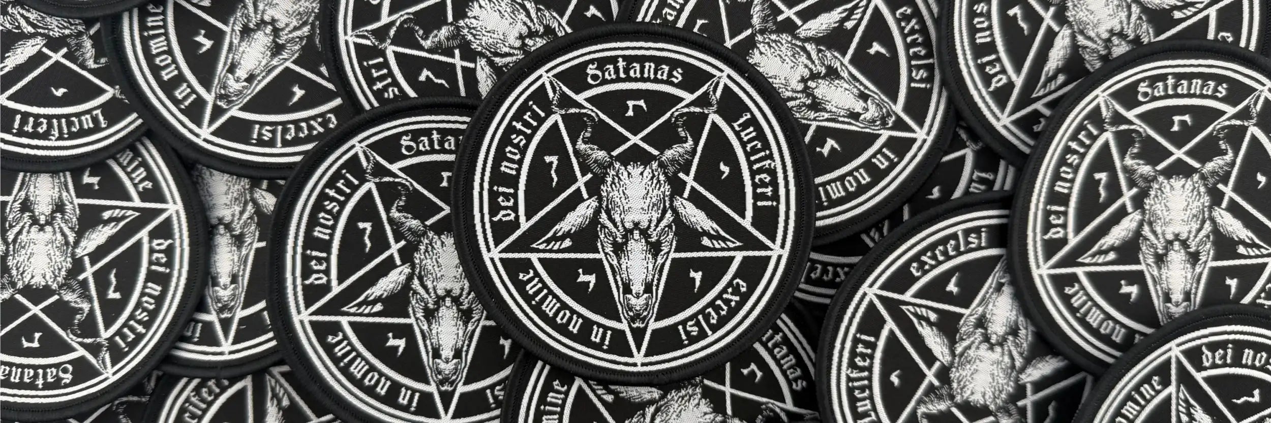 Schwarze runde Flecken mit einem weißen Pentagramm, das eine ziegenköpfige Figur und lateinischen Text zeigt.
