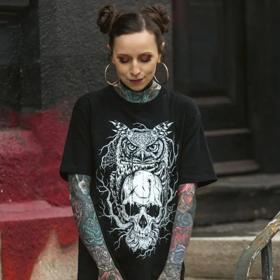 Schwarzes T-Shirt mit einem detaillierten weißen Grafikmotiv einer Eule, die auf einem Schädel thront, umgeben von aufwendigen, zweigartigen Mustern.
