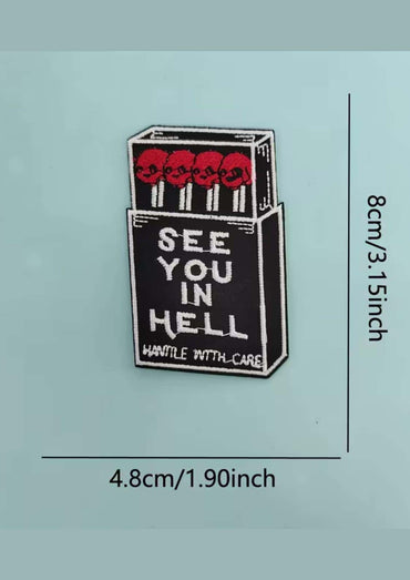 Schwarzer gothic enamel pin in form einer zündholzschachtel mit roten schädeln und weißem see you in hell schriftzug