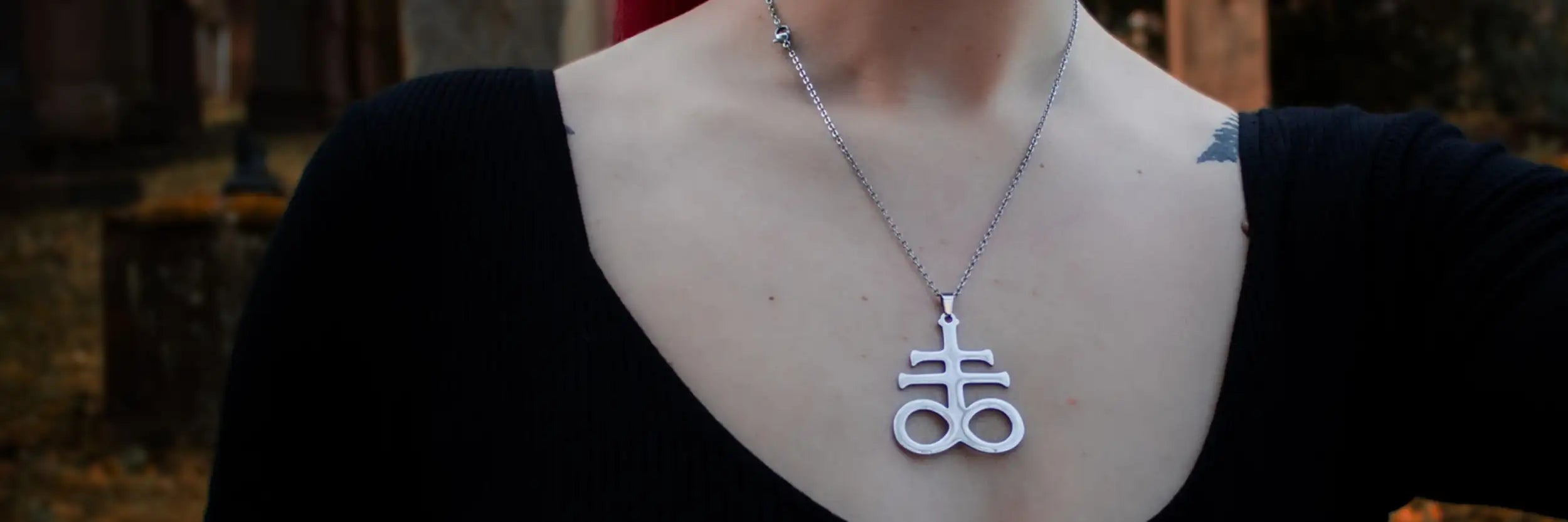 Silberfarbener Anhänger mit einem markanten, stilisierten Anhänger, der ein kompliziertes geometrisches Design aufweist.