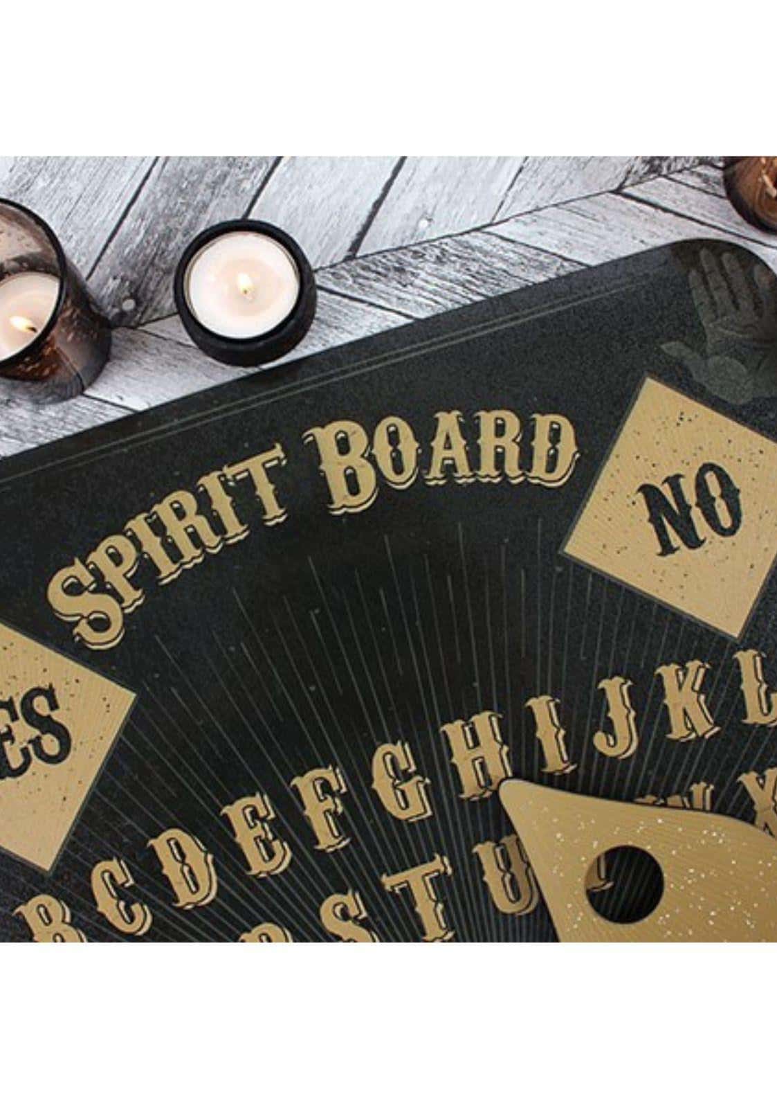 Schwarzes ouija board mit schädelmotiv, goldenen buchstaben und passendem goldzeiger spirit board