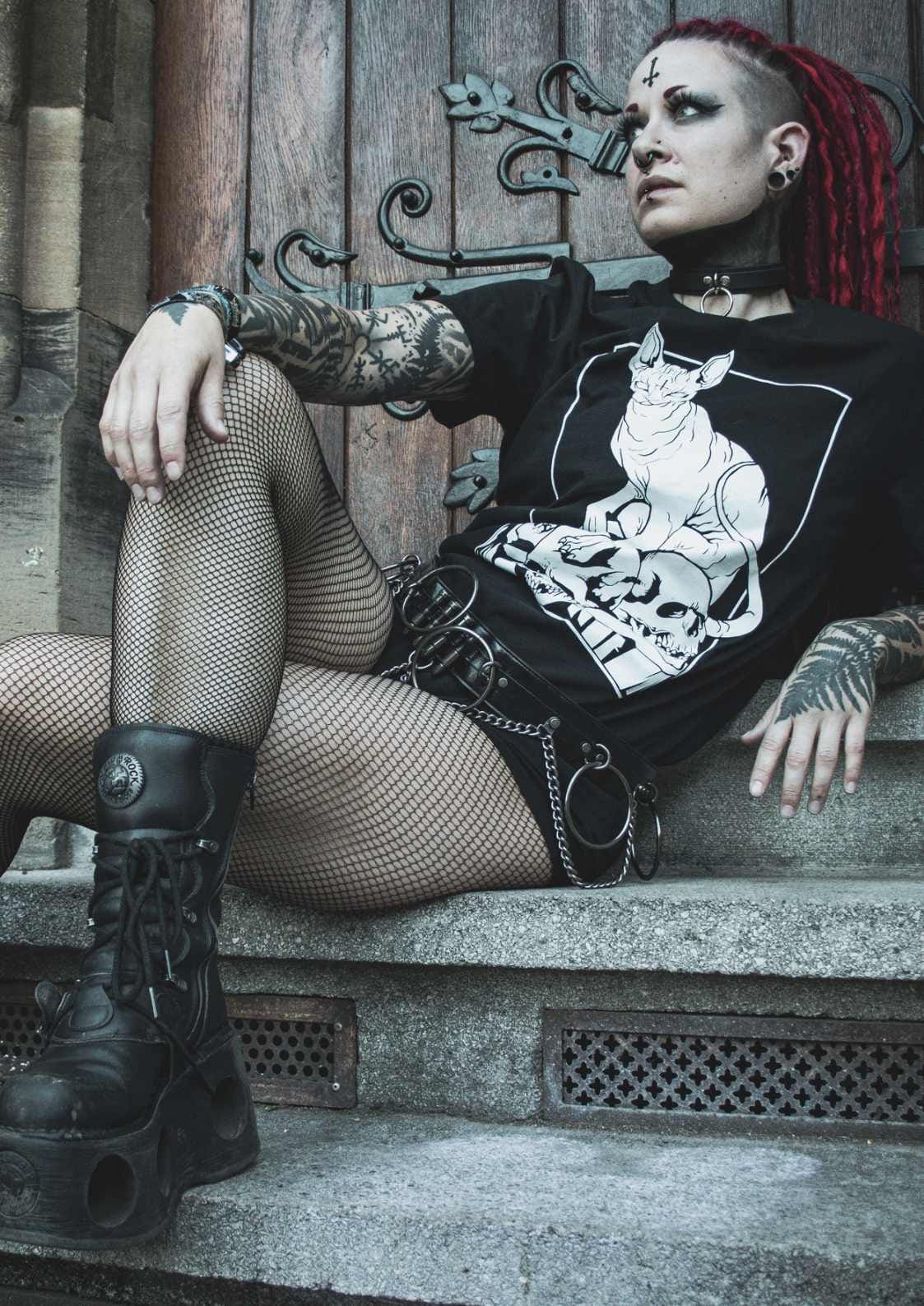 Gothic-Frau in Netzstrümpfen und Plateaustiefeln.