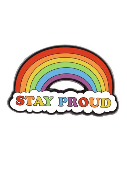 Regenbogenfarbene Emaille-Anstecknadel mit dem Text ’stay proud’ in bunten Buchstaben.