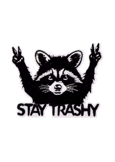 Schwarz-weiß bestickter stay trashy patch mit einem waschbären der peace zeichen macht im gothic horror stil