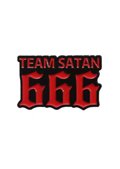 Eine schwarz-rote Emaille-Anstecknadel ’Team Satan 666’’.