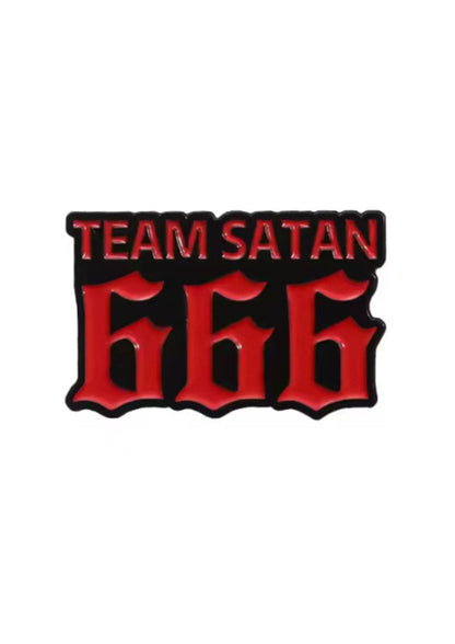 Eine schwarz-rote Emaille-Anstecknadel ’Team Satan 666’’.