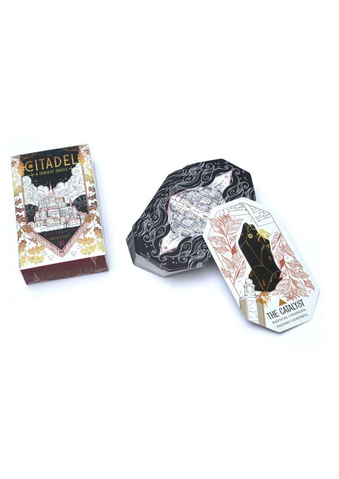 Schwarzweiße sechseckige metalldose mit goldfolie und fantasy-stadtmotiv für das citadel fantasy oracle tarot deck