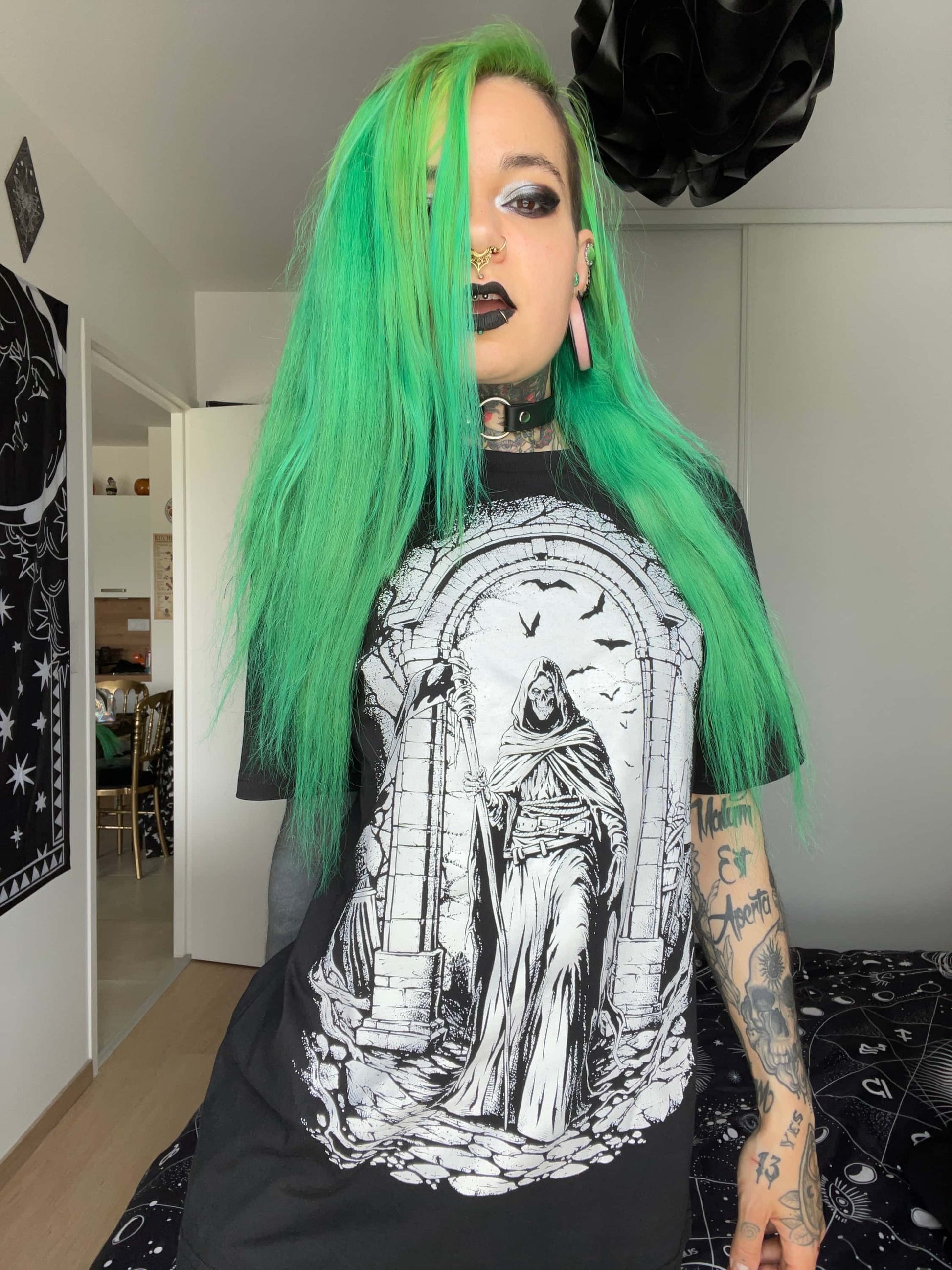 Schwarzes gothic t-shirt mit weißem horror-motiv eines kapuzenmanns im bogenfenster umgeben von fliegenden fledermäusen