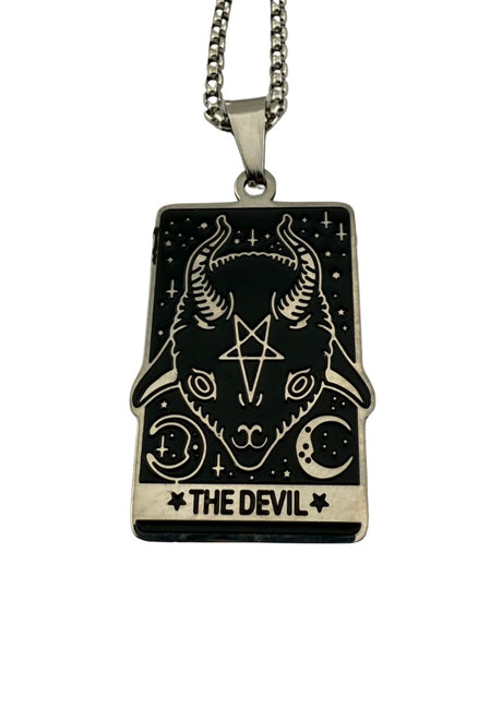 Ein schwarz-weißer Tarotkarten-Anhänger ’Der Teufel’ an einer Silberkette.