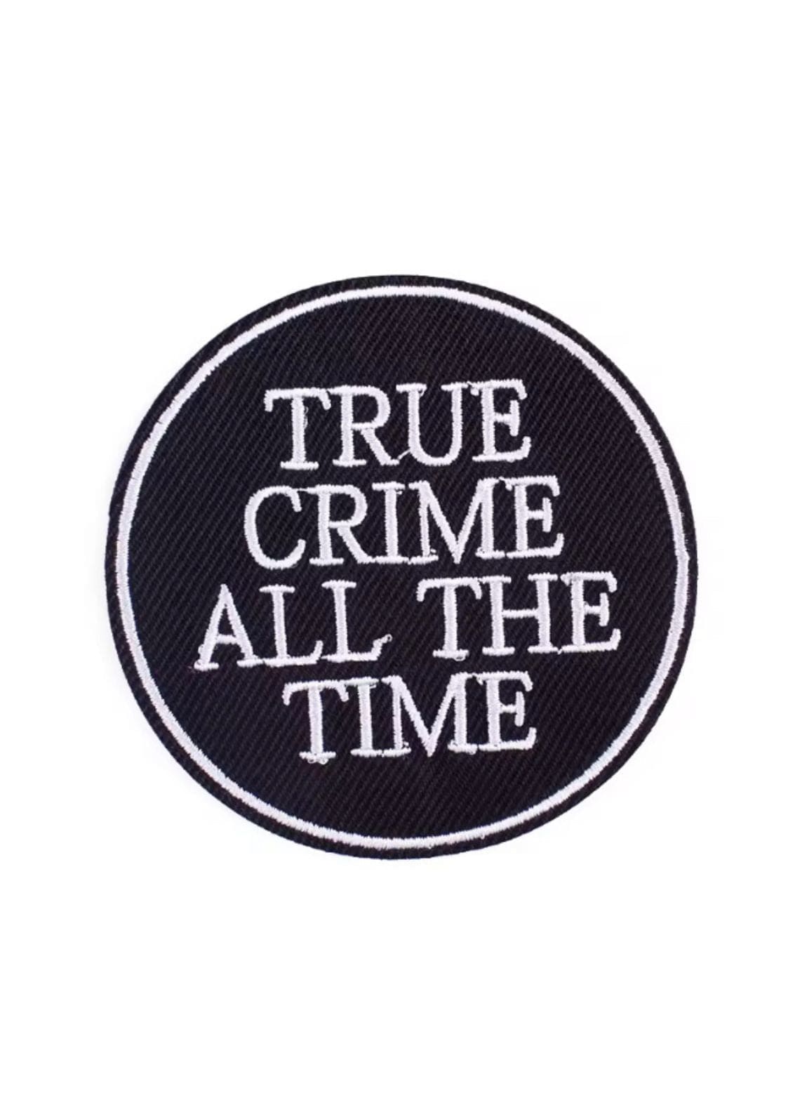 Schwarzer runder Aufnäher mit weißem Text „true crime all the time“ und bestickten Rändern.