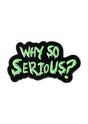 Ein schwarzer Emaille-Anstecker mit einem tropfenden grünen ’why so serious?’ Textdesign.