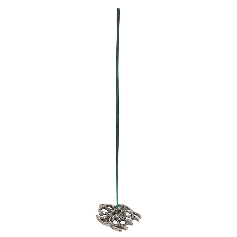 Ein schlanker grüner räucherstab steht in einem silberfarbenen, blattförmigen halter für zombie repellent dragon’s blood incense sticks